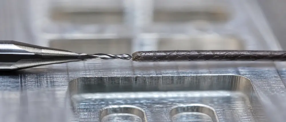 Solid carbide micro end mill compared with human hair on Al6061 aluminum showing micro CNC machining scale at Dazao Solid carbide micro end mill compared with human hair on Al6061 aluminum showing micro CNC machining scale at Dazao