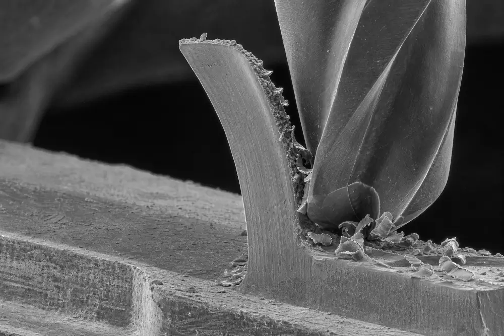 Scanning electron microscope view of micro milling process showing thin wall deflection and aspect ratio limits Scanning electron microscope view of micro milling process showing thin wall deflection and aspect ratio limits